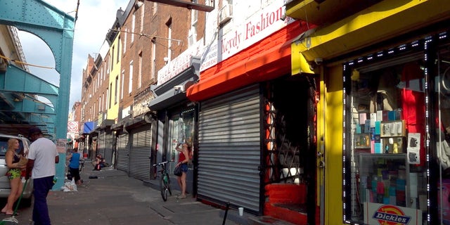 People loiter around shops in Philadelphia's open-air drug market