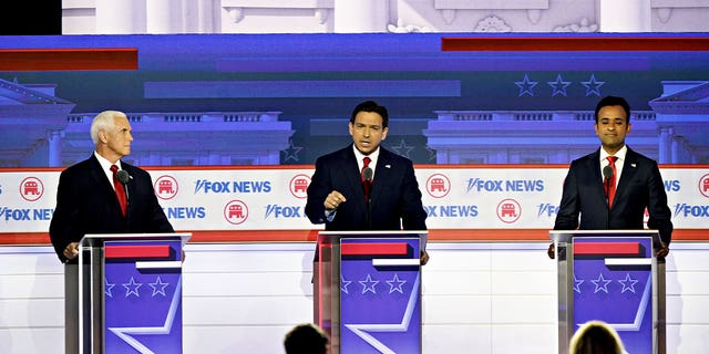 l-r: Mike Pence, Ron DeSantis, Vivek Ramaswamy at debate lecterns