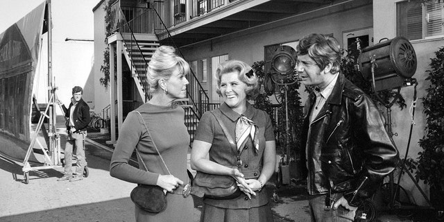 Doris Day and Rose Marie walking together on set as they smile at each other