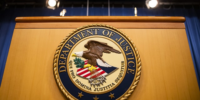 The U.S. Department of Justice seal on a podium in Washington, D.C., U.S., on Thursday, Aug. 5, 2021. The Justice Department has opened an investigation into the City of Phoenix and the Phoenix Police Department looking into types of use of force by Phoenix police department officers.
