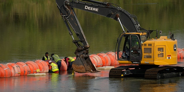 Workers make adjustments to buoys 