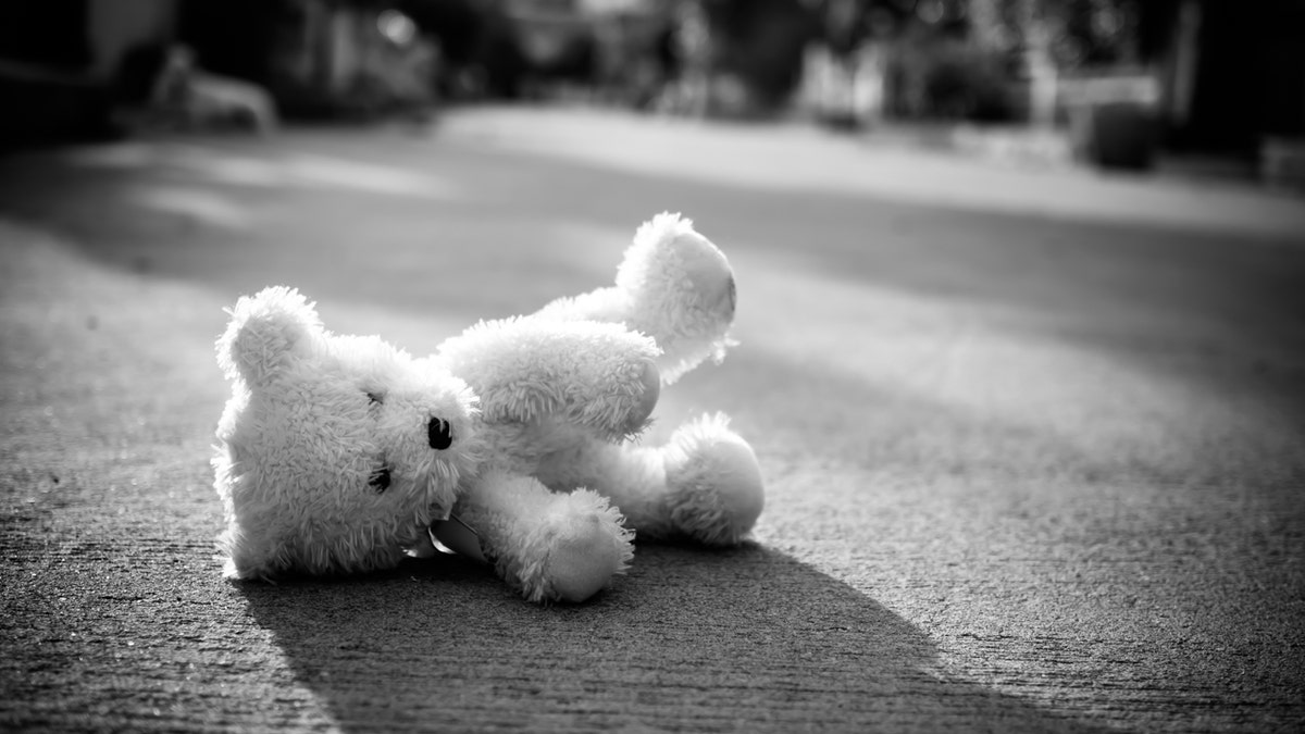 Stuffed bear lies on the ground