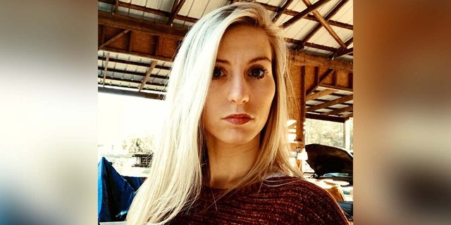 Blonde woman stares at camera in headshot.