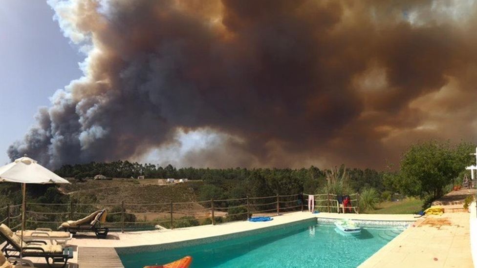 a swimming pool with smoke in the background