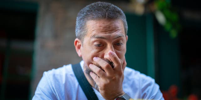 Man holds hand over mouth in shock looking at his phone