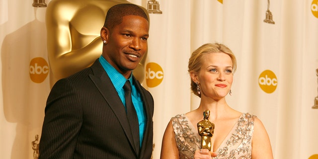 Jamie Foxx stands alongside Reese Witherspoon at Academy Awards