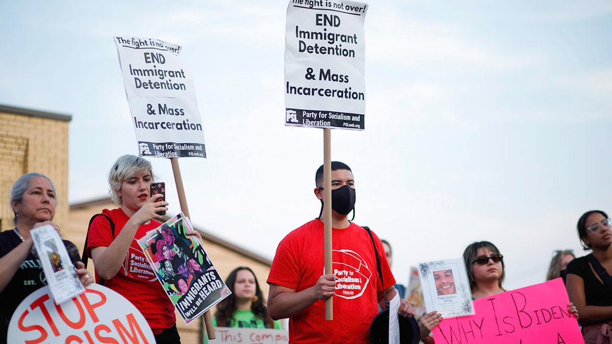 Protesters hold anti-ICE signs