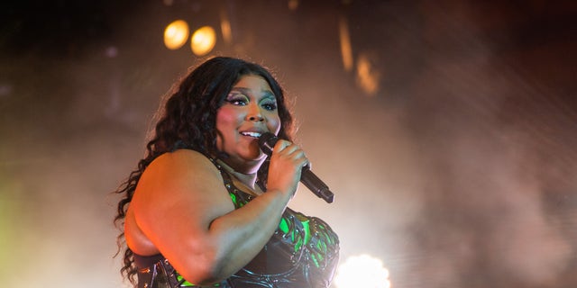 Lizzo performing on stage with a microphone
