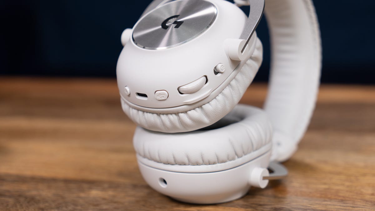 Logitech G Pro X 2 lying on its side with the earcups stacked to show the power switch, mute and Bluetooth buttons, volume dial and USB-C connection  on the right earcup