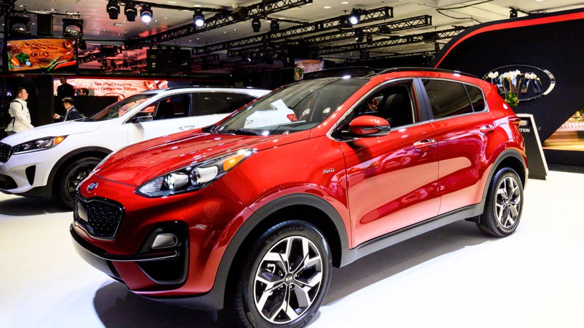 A red Kia car displayed at a car show 