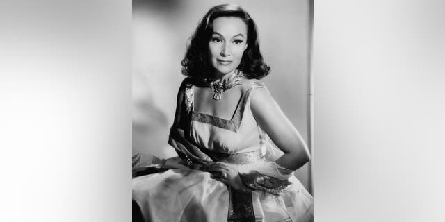 Dolores Del Rio posing in a sleeveless dress and scarf