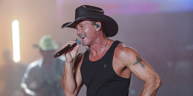 Tim McGraw performs in a tank top