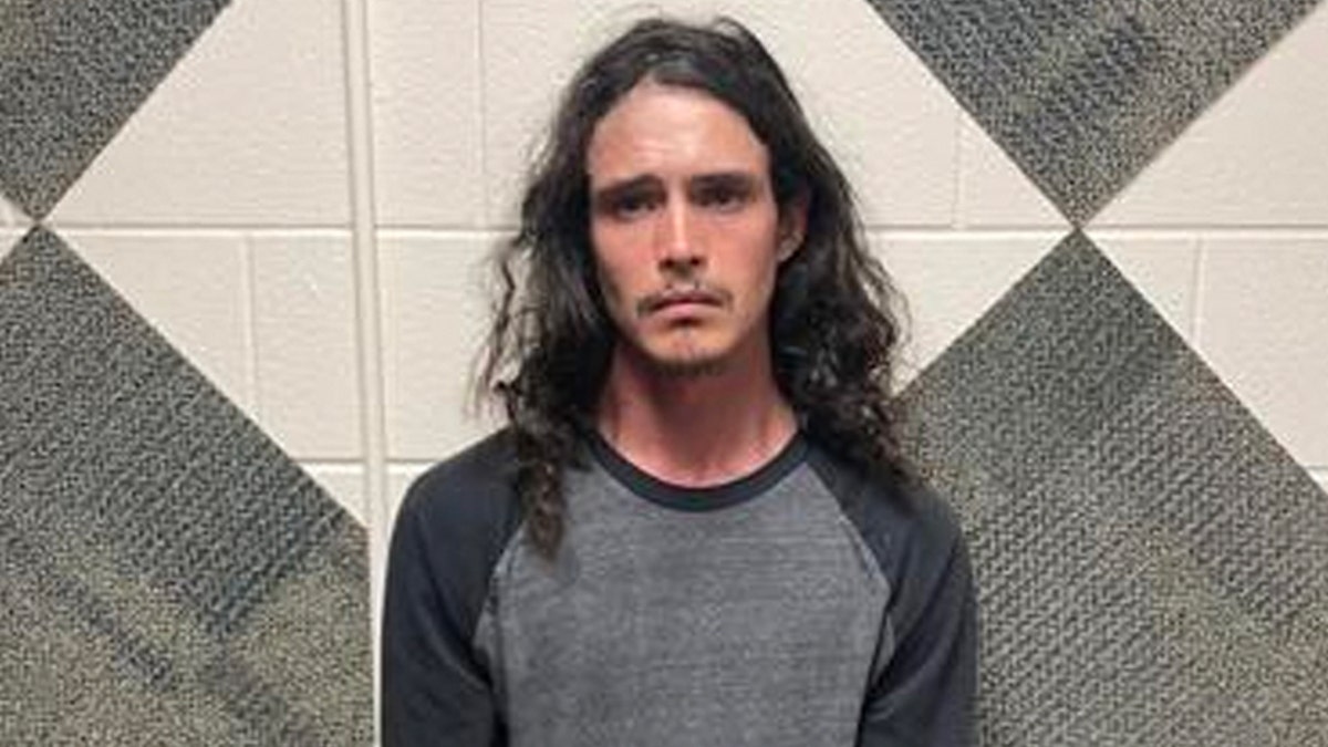 Miles Kirby mug shot, gray shirt long hair