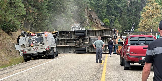 People checking the scene of an overturned school bus 