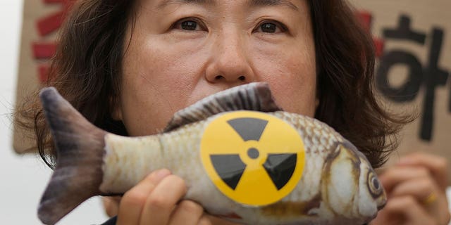 woman holds fish toy