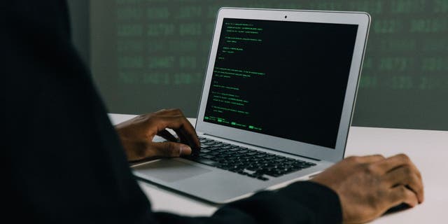 Hacker using his laptop.
