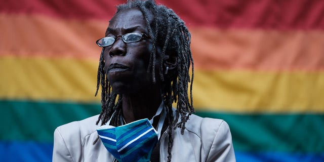Hardesty in front of pride flag