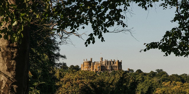 A landscape view of Belvoir Castle surrounded by trees