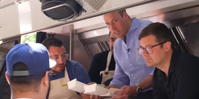 Prince William holding burgers in a food truck