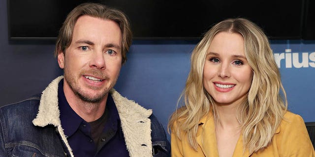 Dax Shepard in a sherpa jean jacket sits next to Kristen Bell in a custard colored jacket