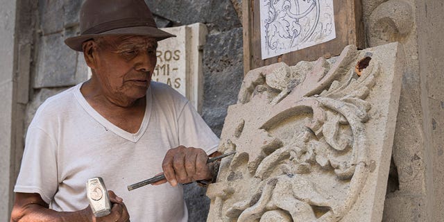 man carves stone