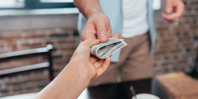Money being exchanged between two people