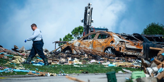 Investigator walking through debris