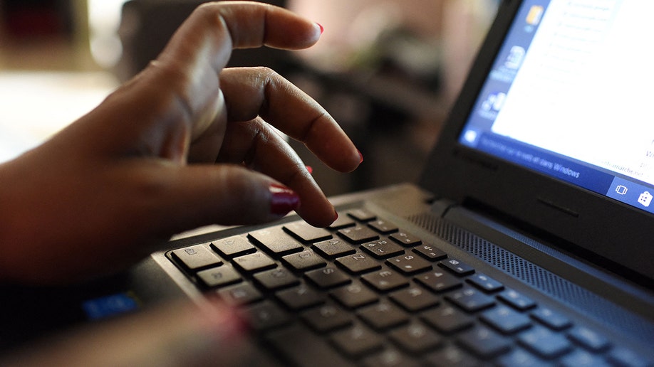A person typing on a laptop