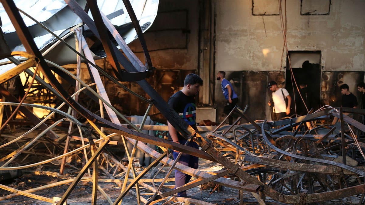 man stands in destroyed wedding halll