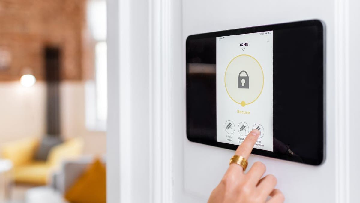 Photo of a woman setting up her alarm system.