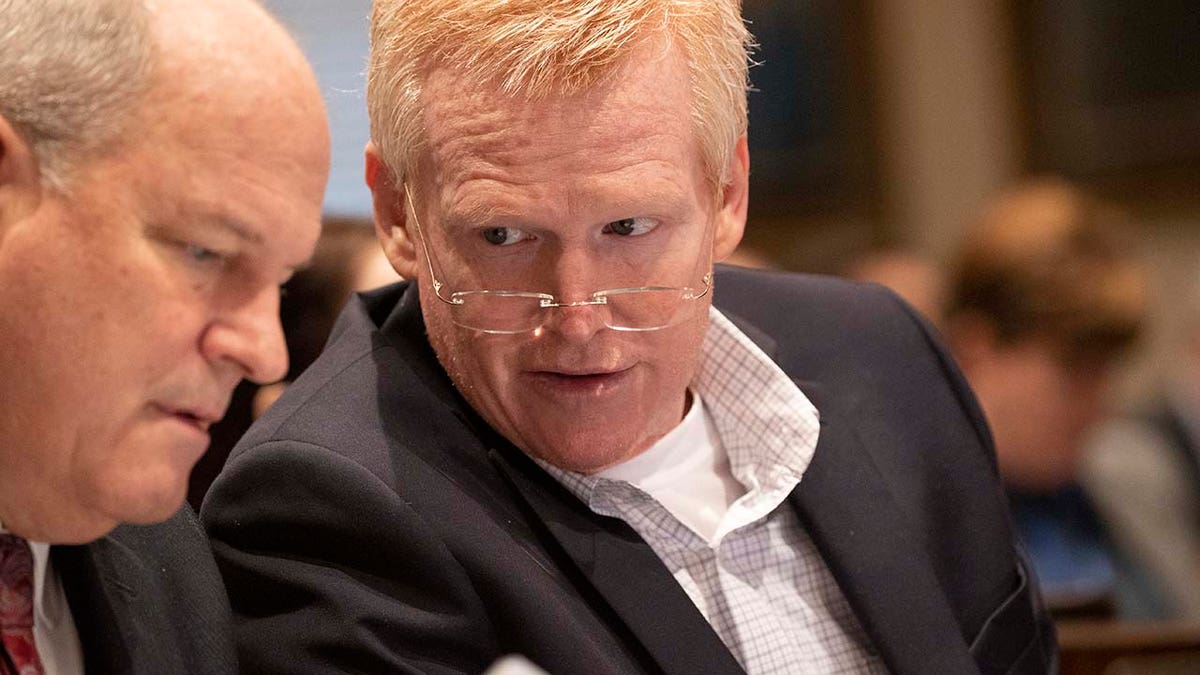 Two men speak while inside a courtroom.