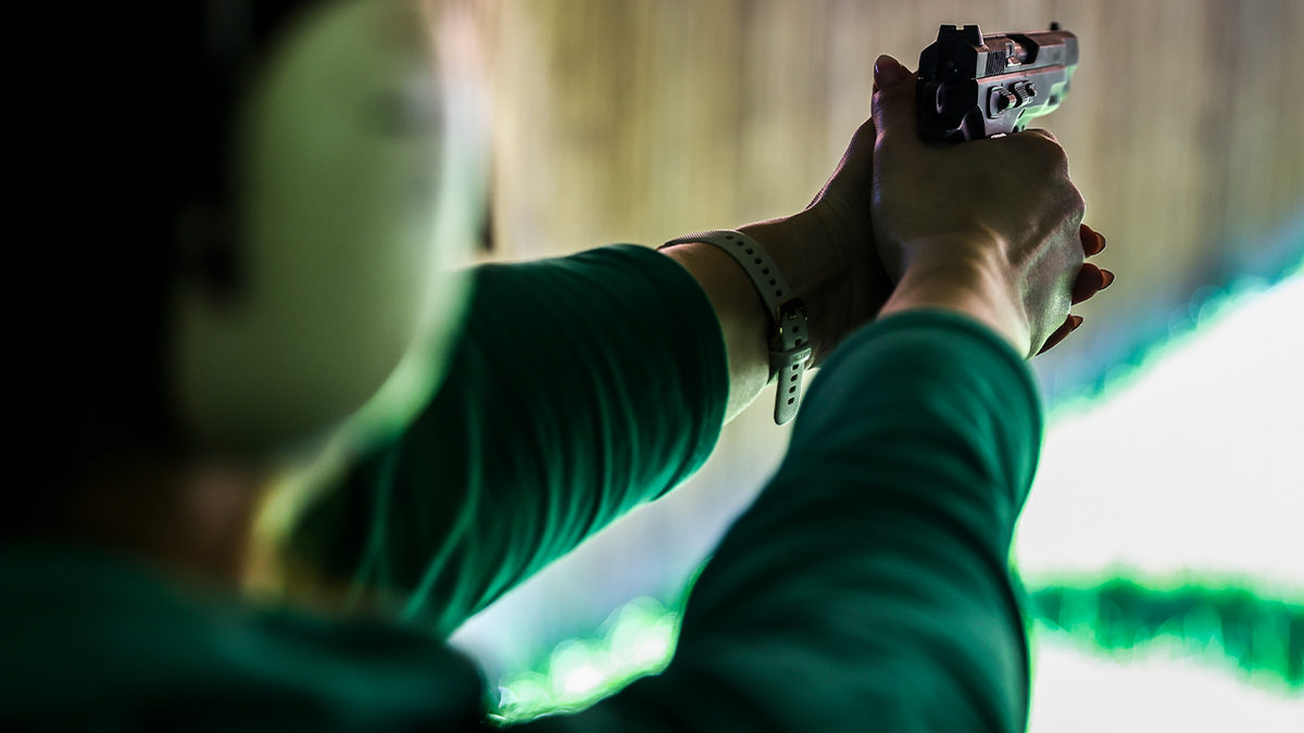 Woman shooting gun stock image