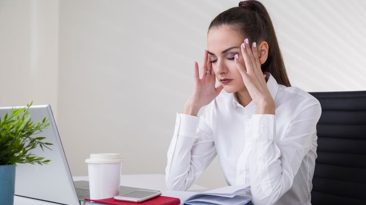 Woman upset and placing her hands on her head.