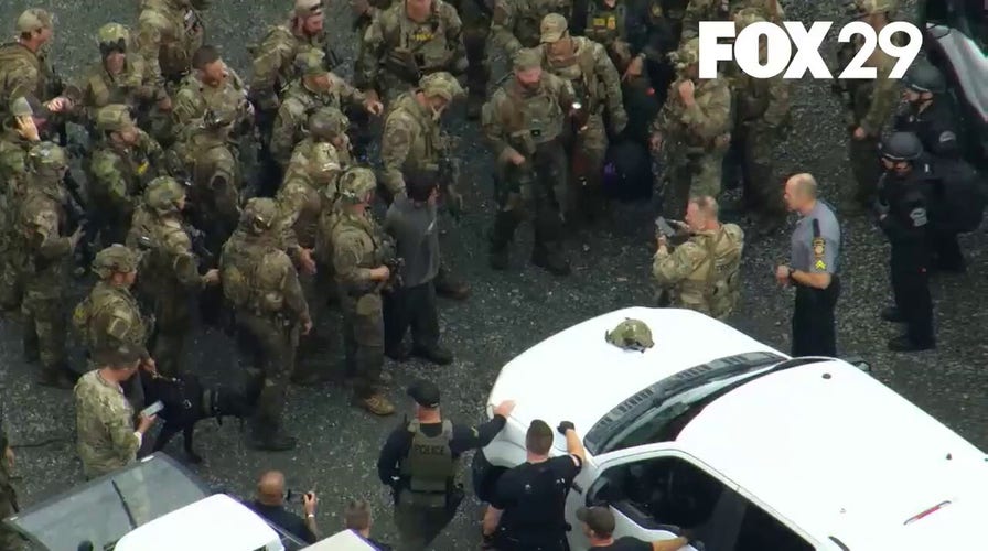 Law enforcement pose for a photo after capturing Danelo Cavalcante