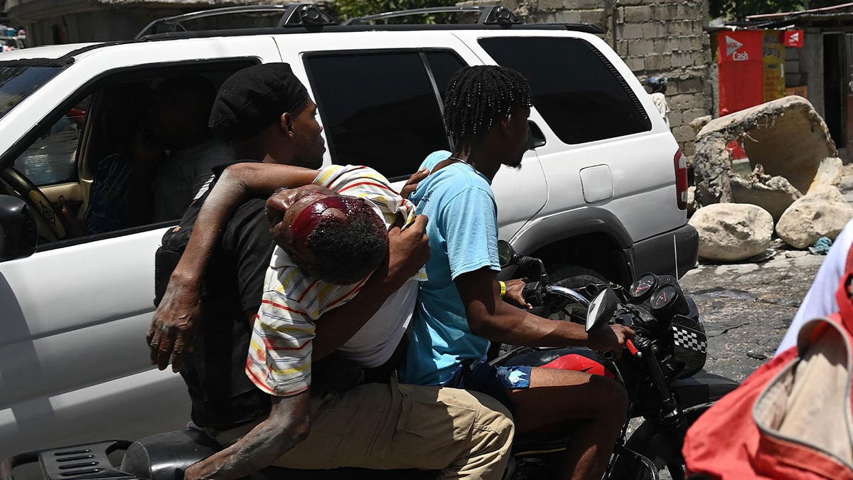 man carries wounded victim