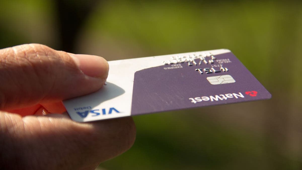 Person handing over their credit card.