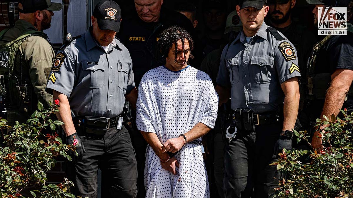 Danelo Cavalcante is escorted out of the Pennsylvania Police Headquarters