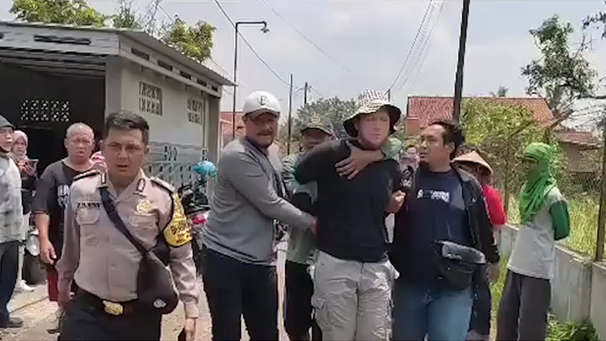 American man being arrested in Indonesia