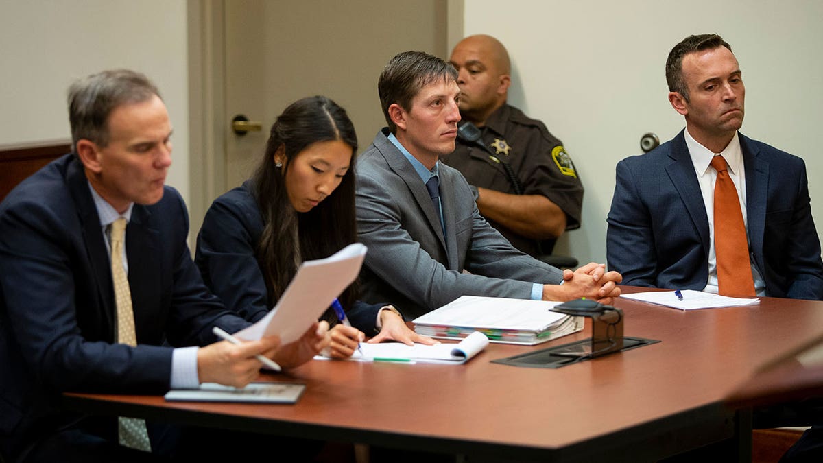 Christopher Schurr listens in court with team