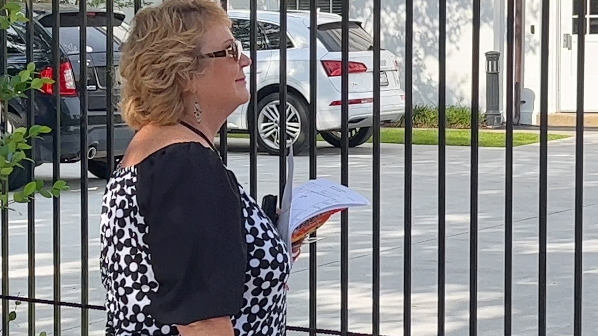 Rebecca Hill, wearing sunglasses and a black and white blouse.