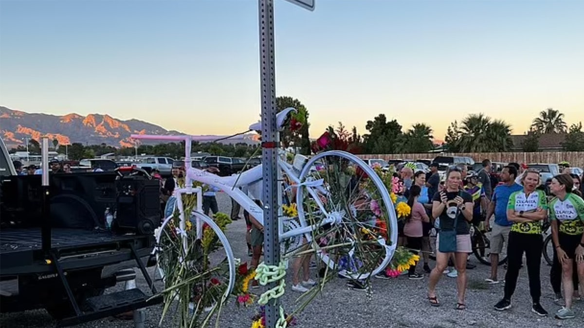 White bicycle hangs from a street sign.