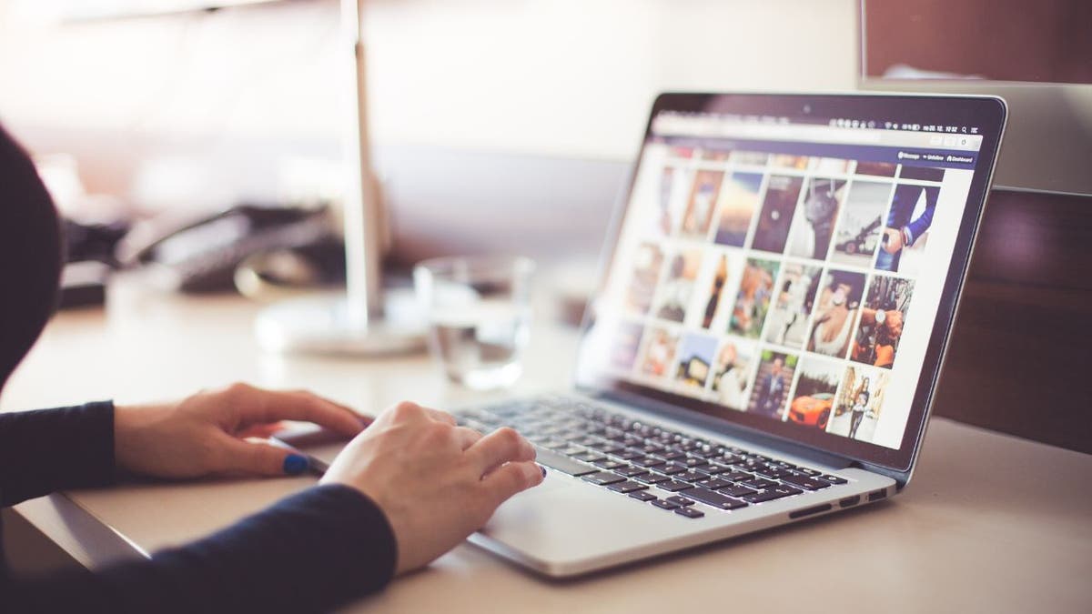 Woman sitting at her laptop, looking at her computer.