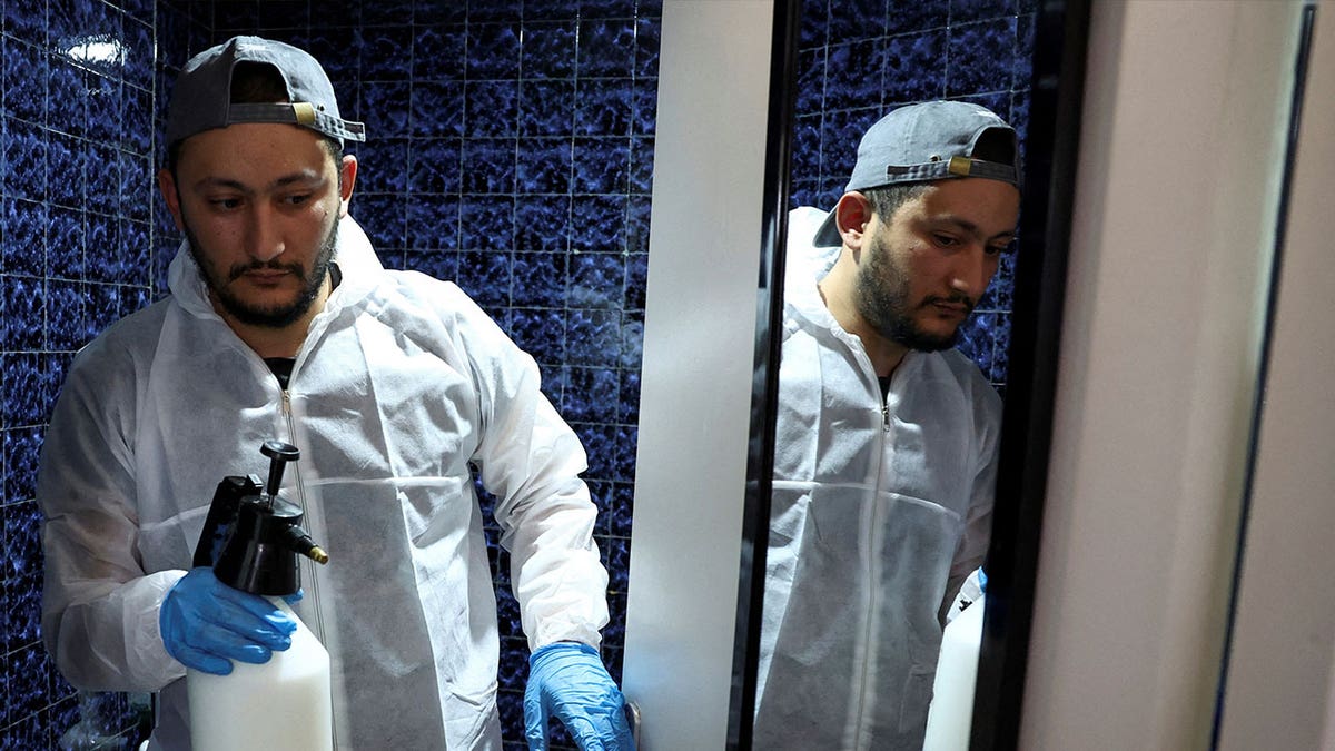 technician holding spray in restroom