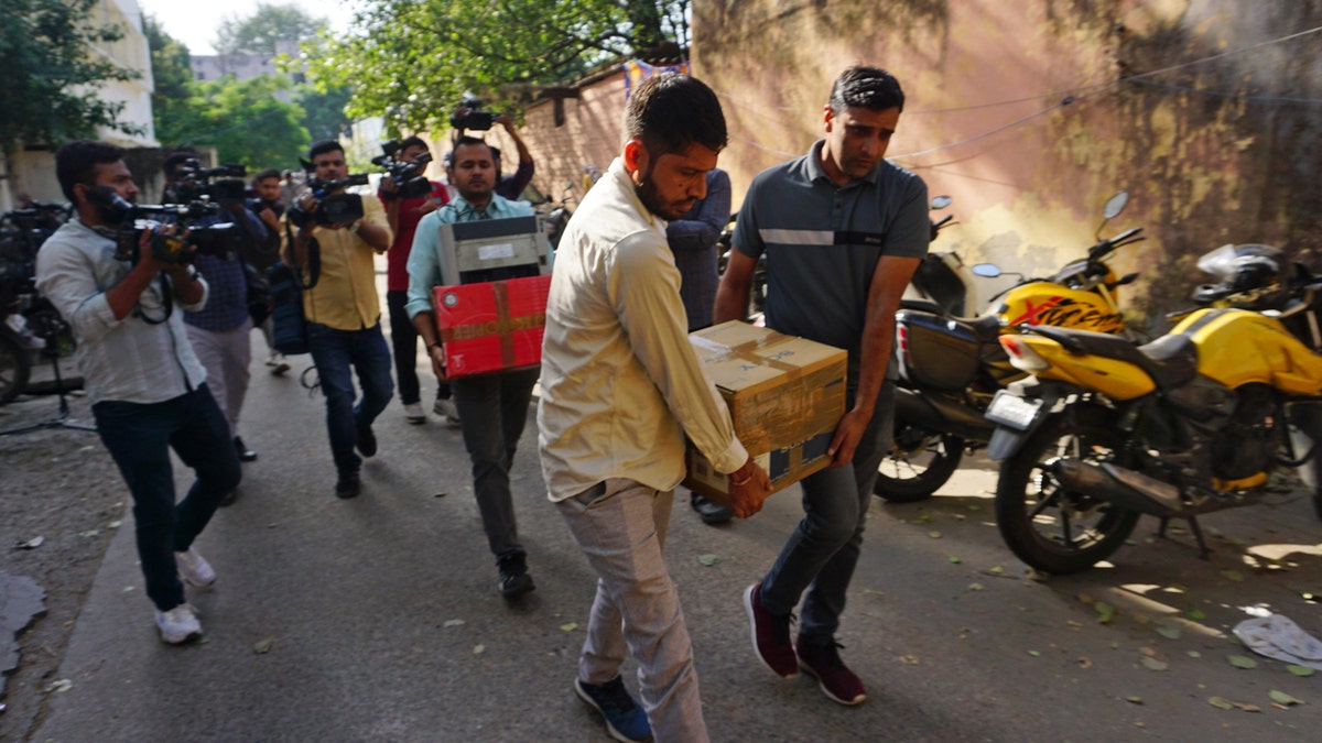 Security offices carrying box from raid
