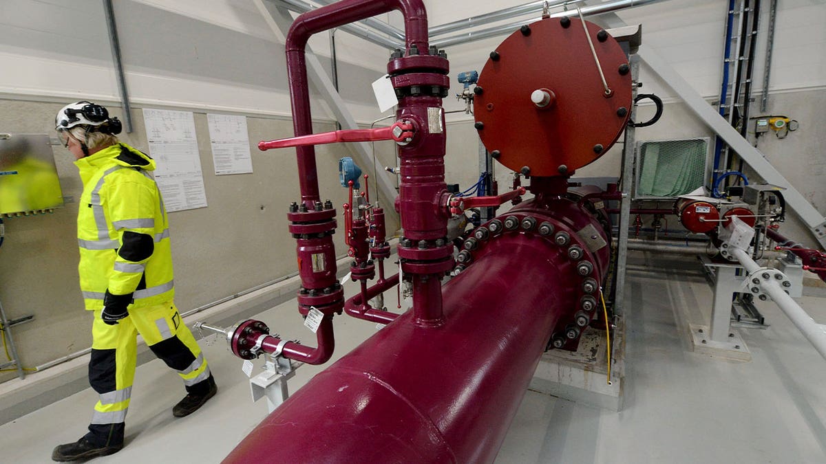 man walks past marine gas pipeline