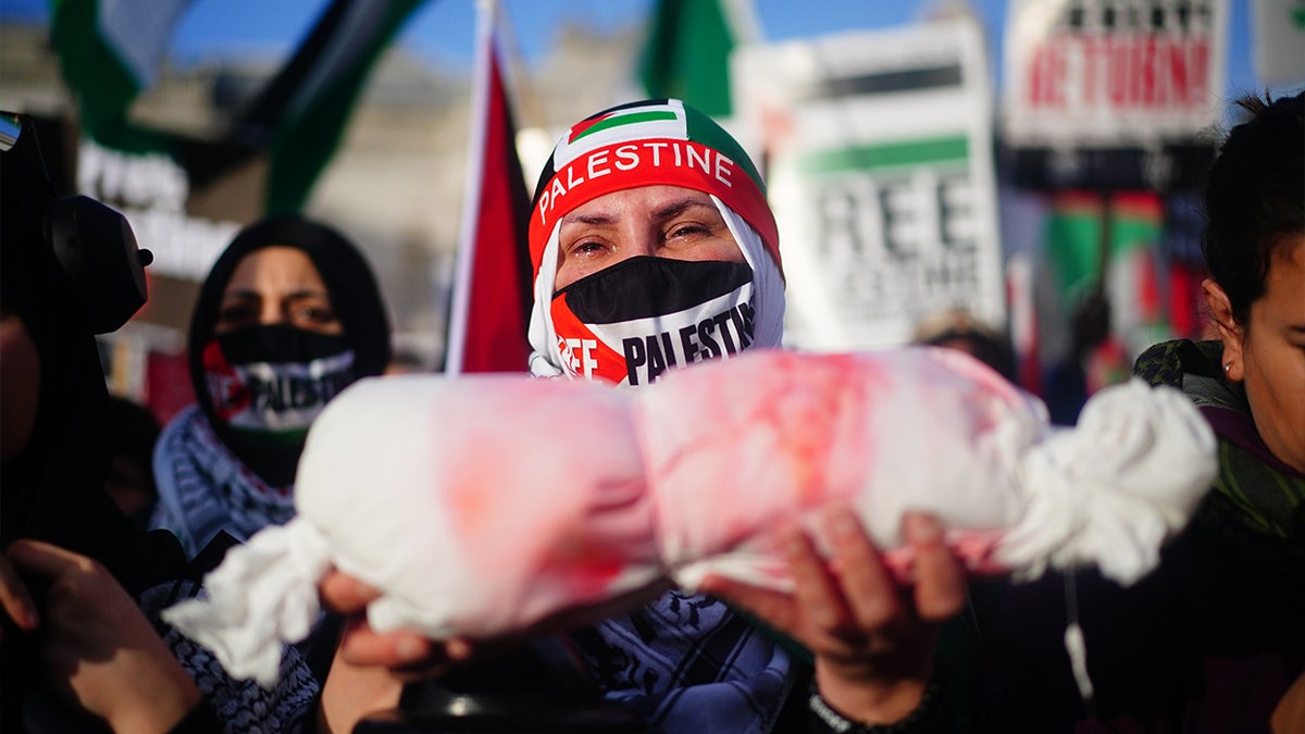 A protester holds up an effigy of a dead baby