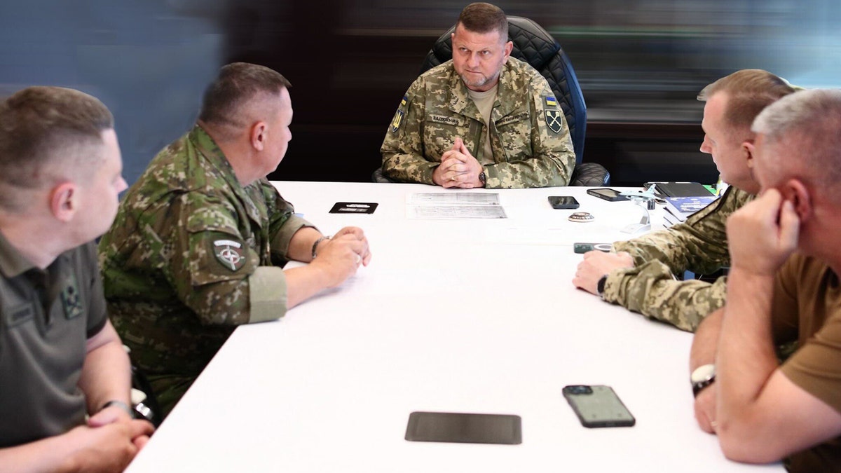 Valery Zaluzhny, dressed in military uniform, sitting down a meeting with other military leaders 