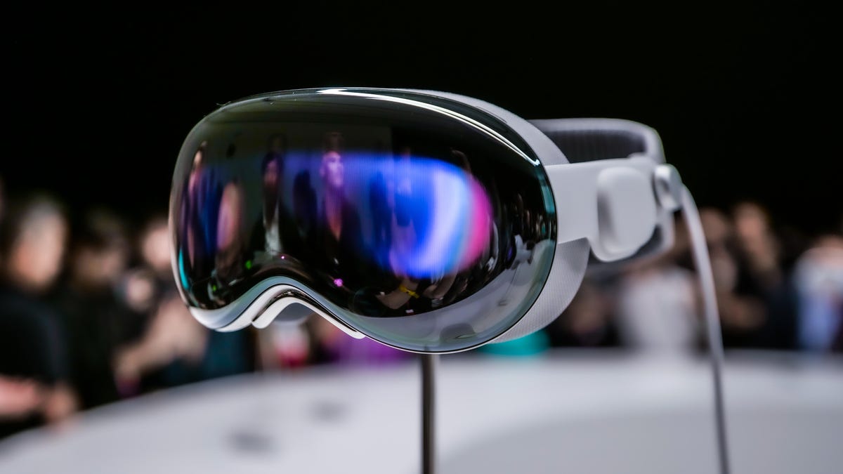 Apple Vision Pro headset on a stand with a cable