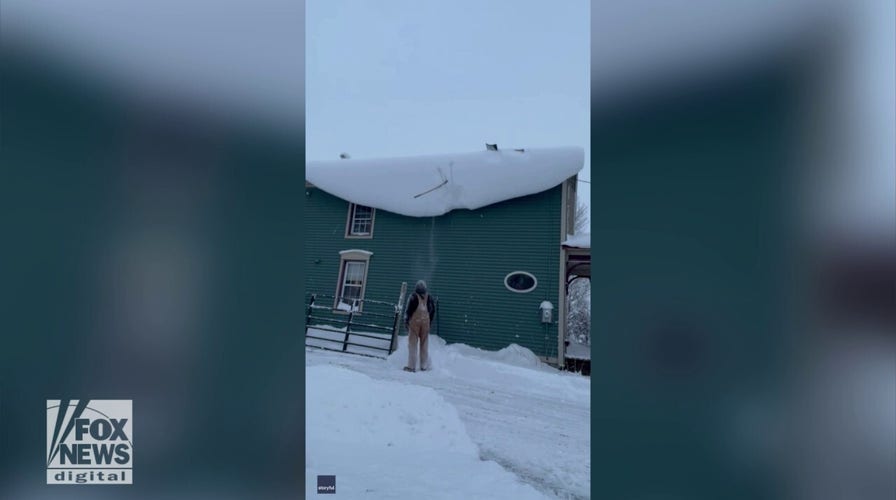 Man’s shovel gets stuck on snowy roof in comedic video