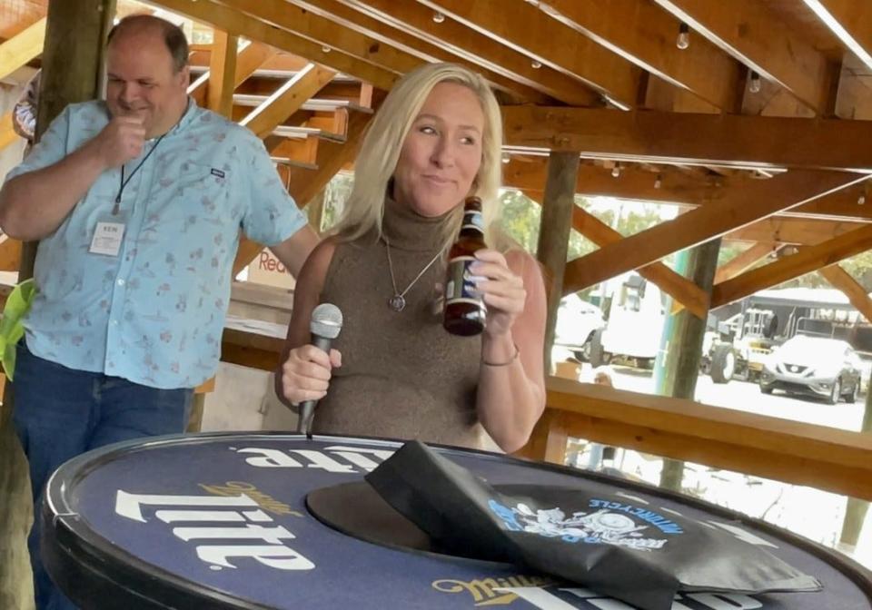 U.S. Congresswoman Marjorie Taylor Green pauses during a speech to sip on a beverage at the Iron Horse Saloon in Ormond Beach on Sunday, Jan. 7, 2024.